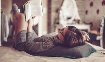 mujer leyendo libro cama